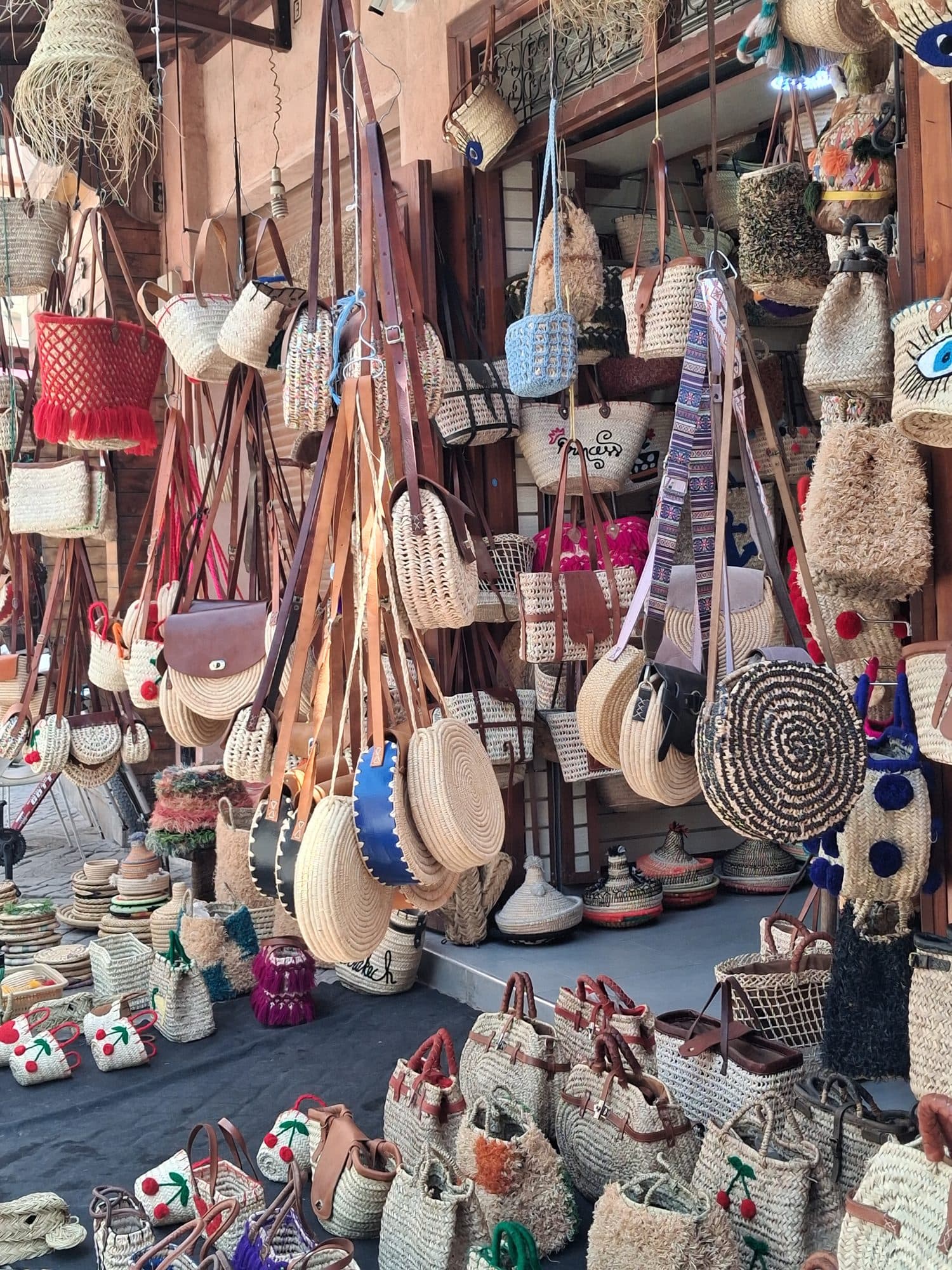 Paniers et sacs tressés en fibres végétales suspendus dans une échoppe de souk