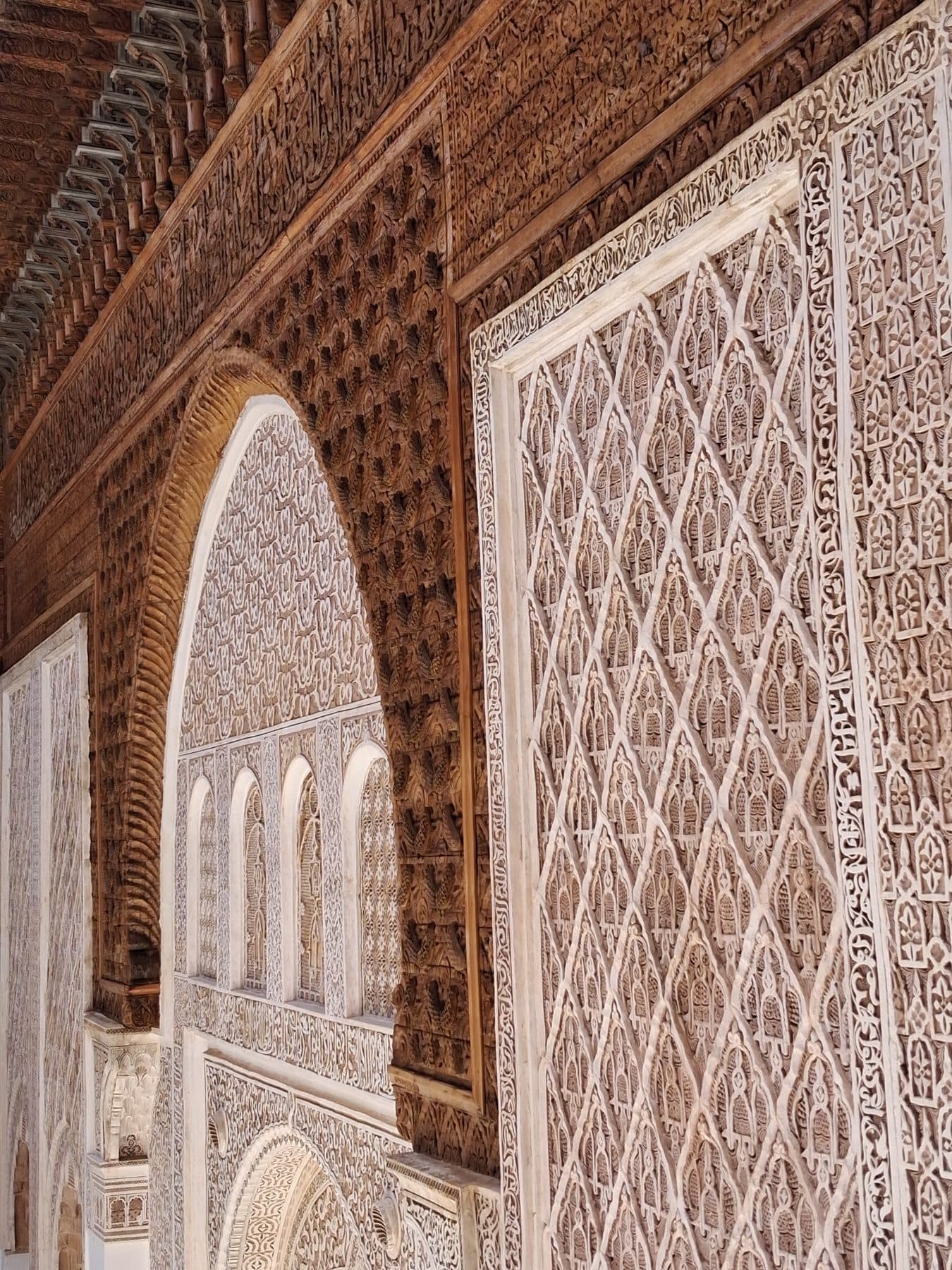 Stuc sculpté et panneaux de cèdre sur les murs de la cour de la médersa Ben Youssef