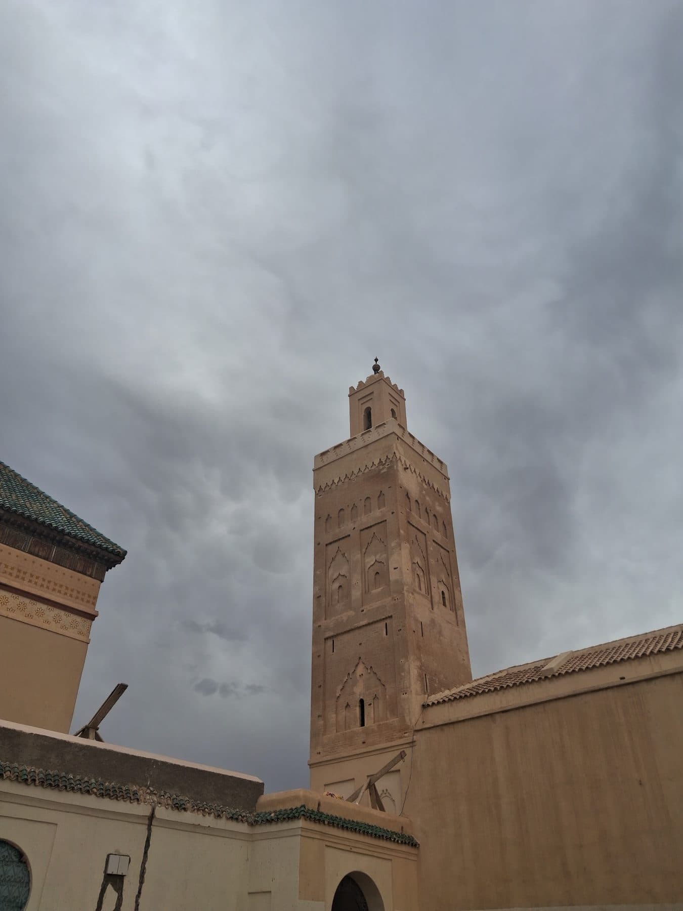 Minaret de la mosquée de la Kasbah à Marrakech sous un ciel d'orage.