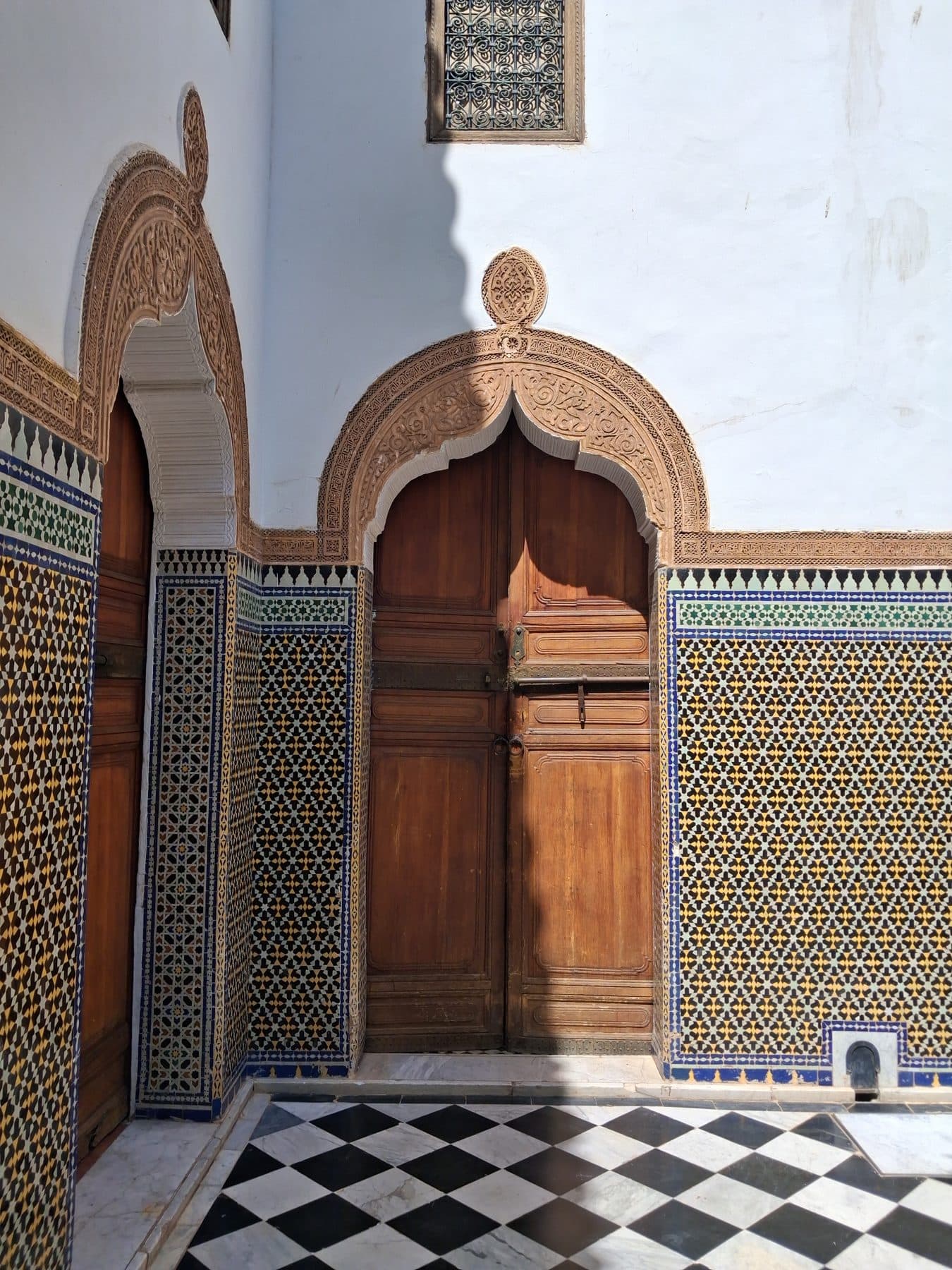 Portes en cèdre sous des arcs de plâtre sculpté, entre des murs de zellige, Dar El Bacha