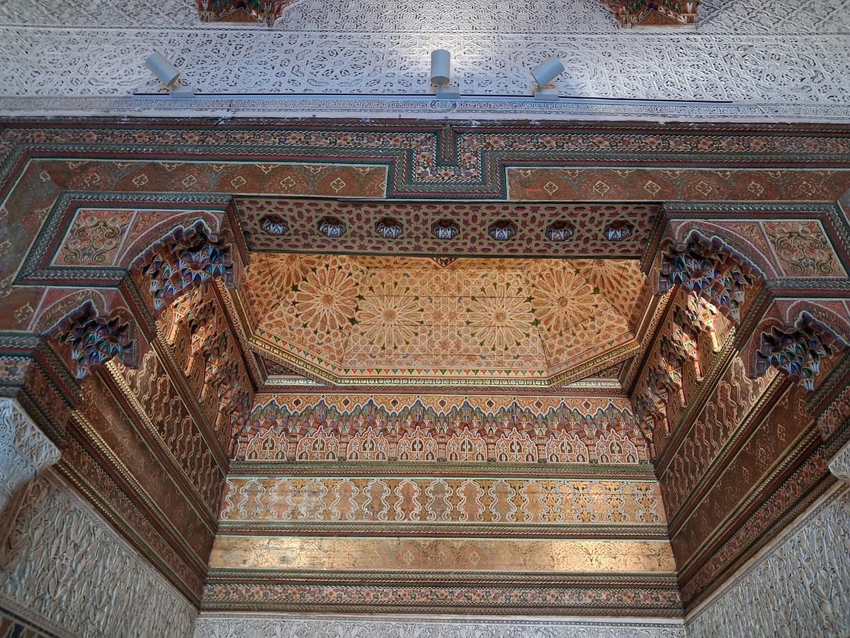 Plafond de bois sculpté et peint au-dessus d'une alcôve, entouré de stuc ciselé, à Dar El Bacha.