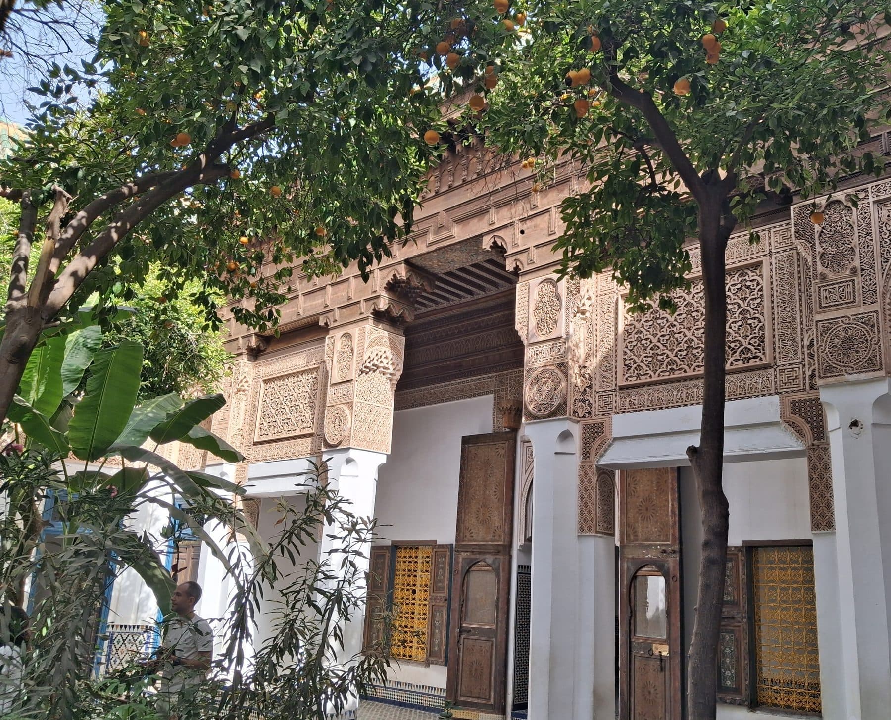 Galerie du palais de la Bahia sous les orangers : colonnes blanches et boiseries de cèdre sculpté