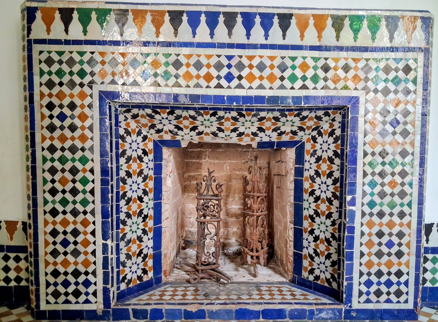 Cheminée du palais de la Bahia entourée d'un grand cadre de zellige aux motifs géométriques