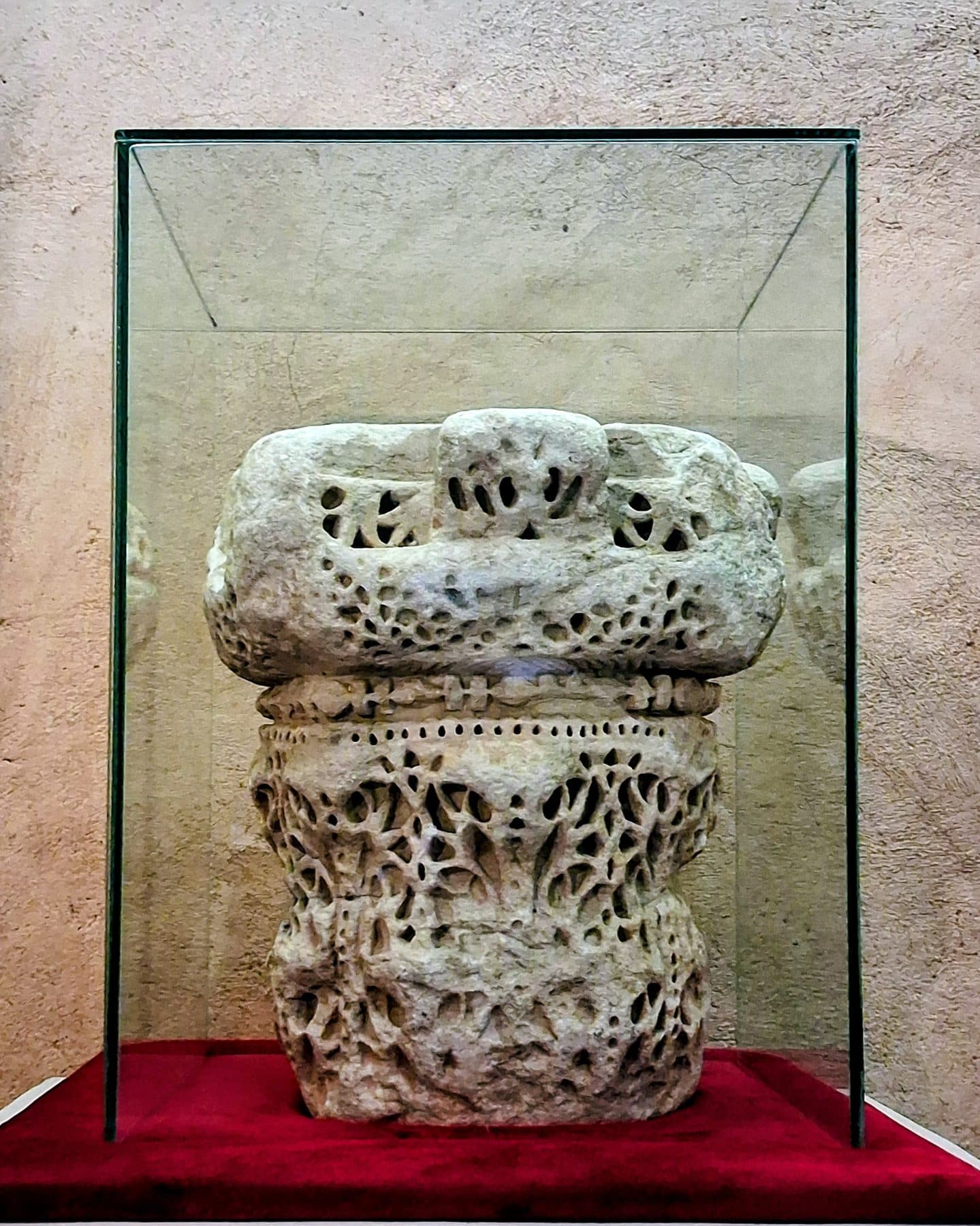 Chapiteau sculpté de motifs ajourés exposé dans une vitrine, palais El Badi