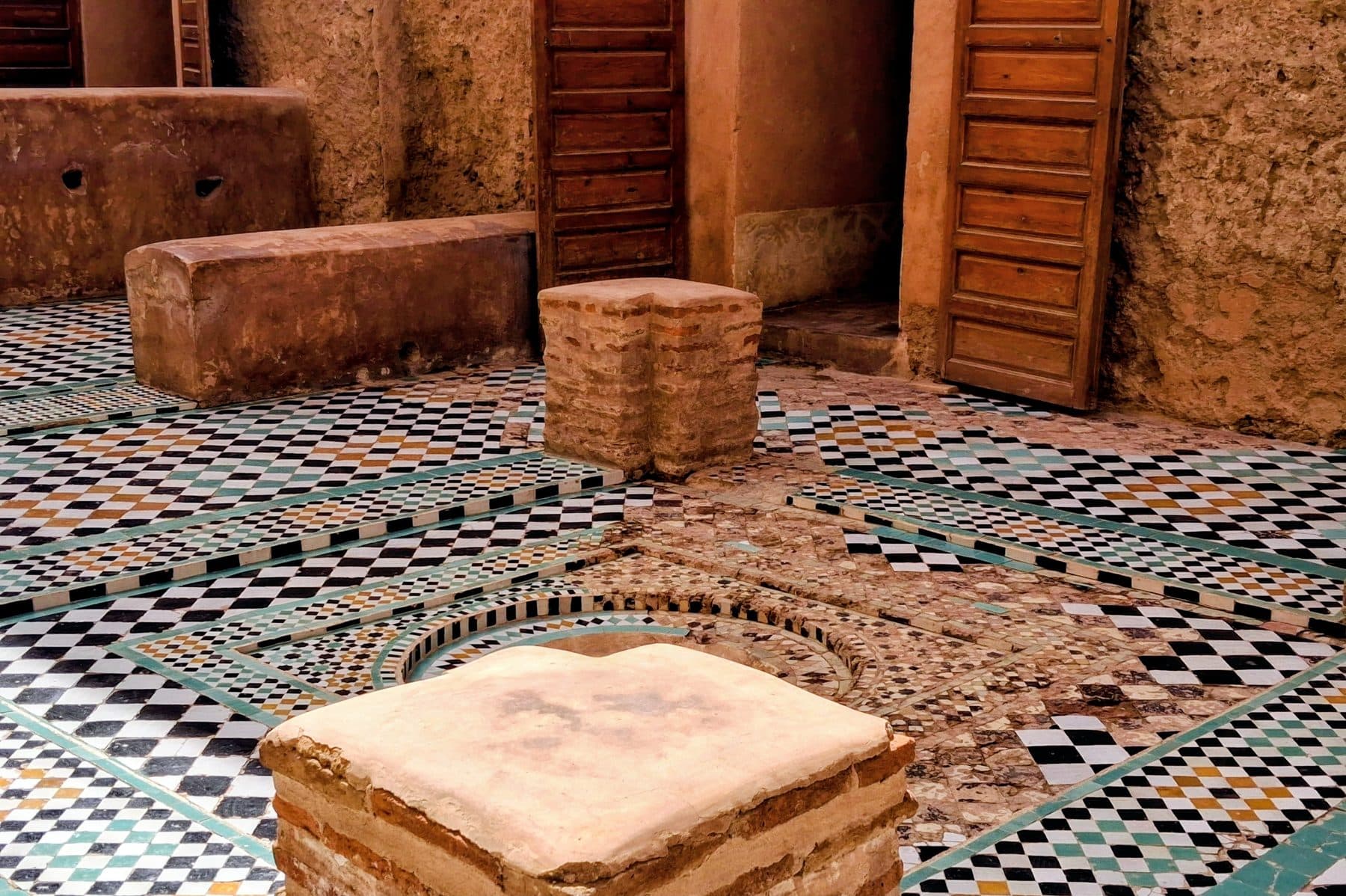 Sol en zellige aux motifs géométriques entre des murs de pisé, palais El Badi