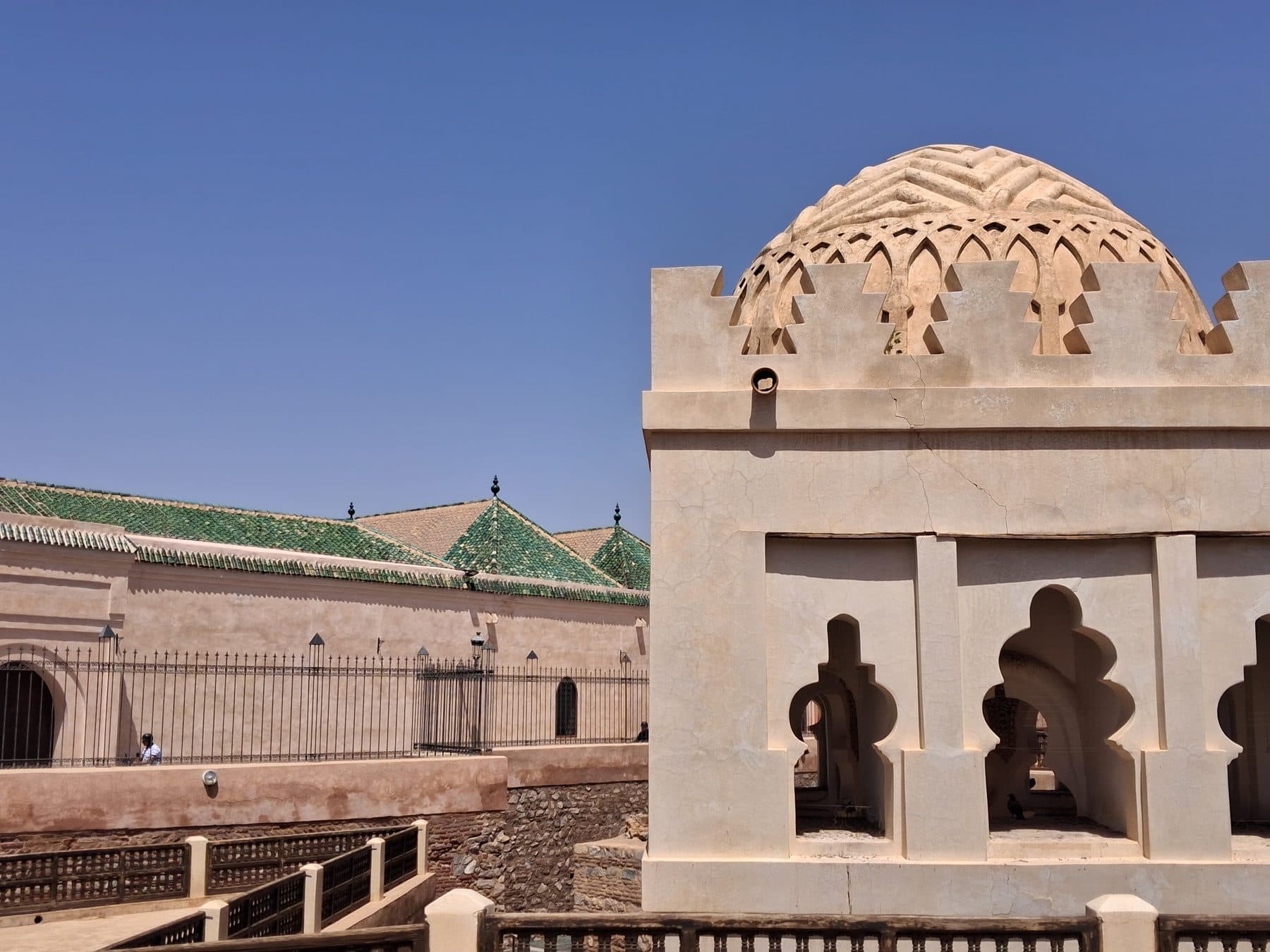 Coupole sculptée de motifs en réseau au-dessus d'une façade percée d'arcs, qoubba almoravide