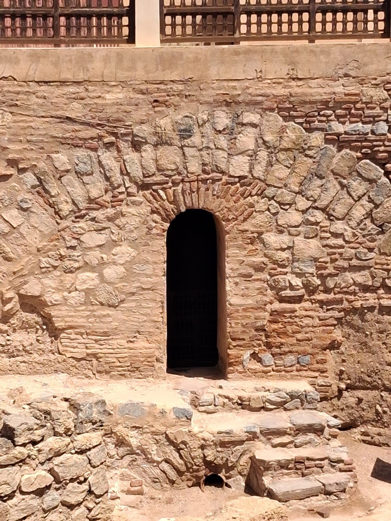 Arc en pierre et en brique d'un vestige mis au jour par les fouilles, près de la qoubba almoravide