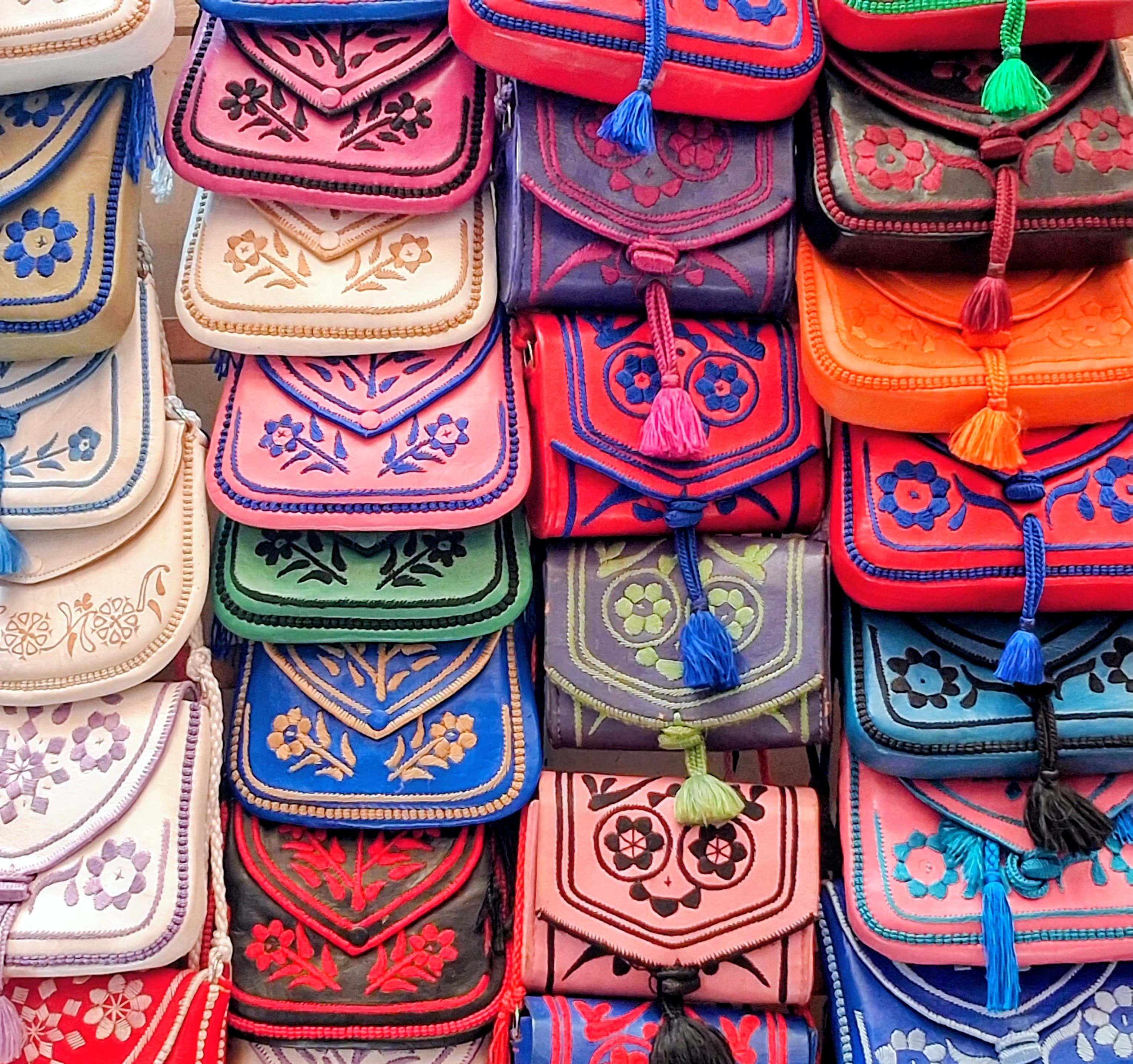 Collection de sacs et pochettes en cuir colorés et brodés de motifs traditionnels marocains pour l'en-tête du site de Marrakech.